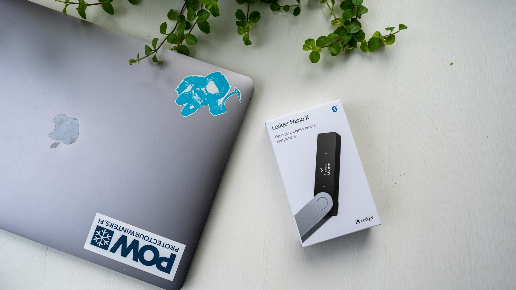Hardware wallet beside a laptop on a desk